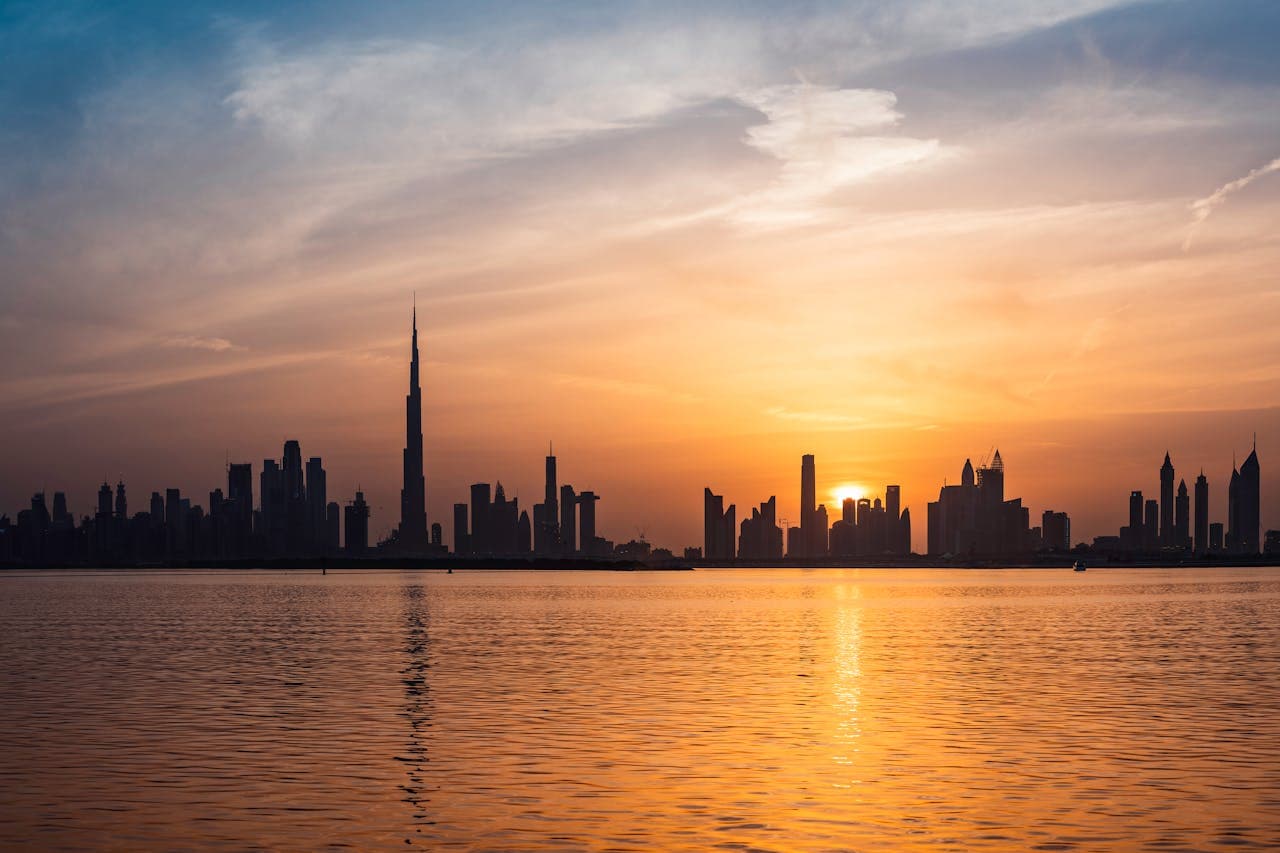 The Dubai skyline at sunset across the water